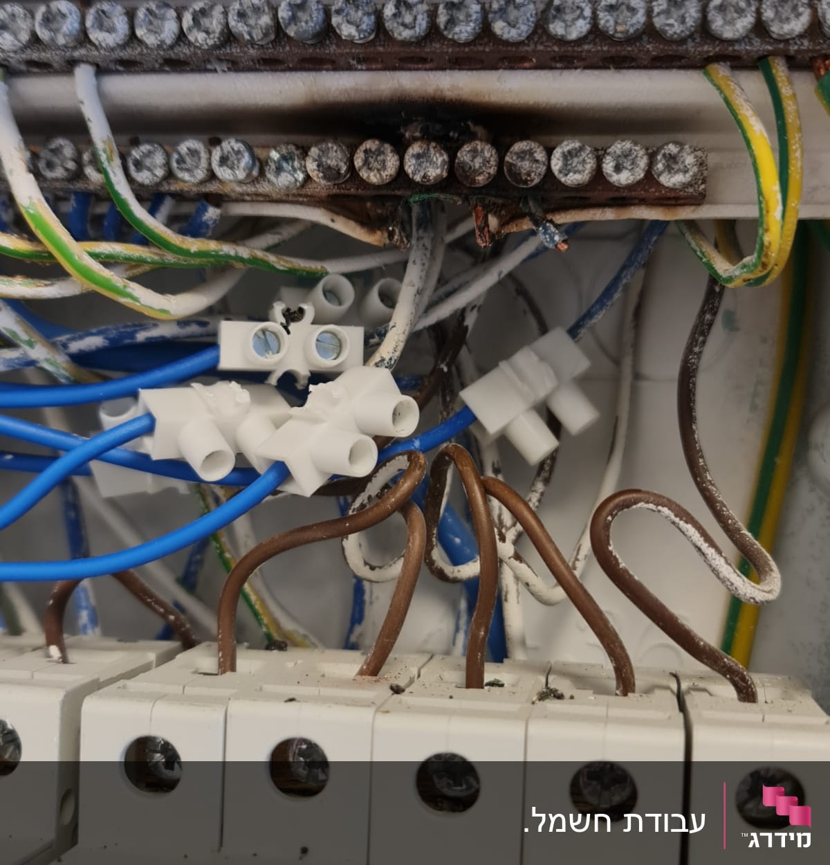 חוטי חשמל צבעוניים ומפסקים בלוח חשמל